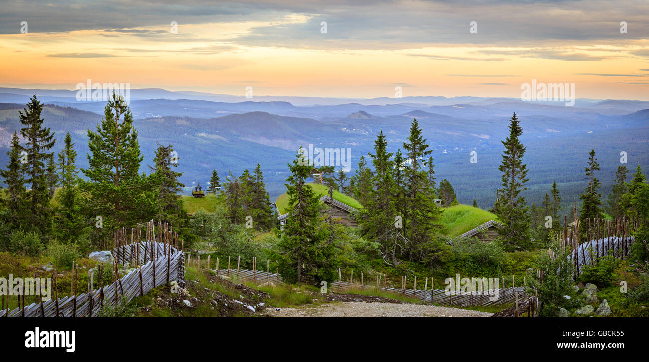 Einige Blockhütten in fast von umliegenden Bäumen versteckt. Melden Sie sich, Zaun umgeben. Panoramaformat. Stockfoto