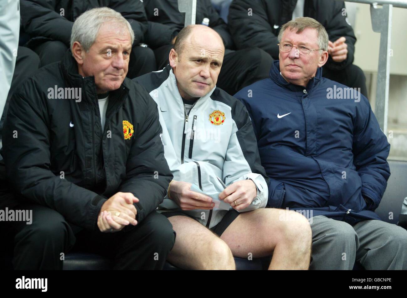 Sir Alex Ferguson (r), Manager von Manchester United, sitzt während des Verlusts gegen Manchester City niedergeschlagen (Walter Smith (l) und Mike Phelan (c)) Stockfoto