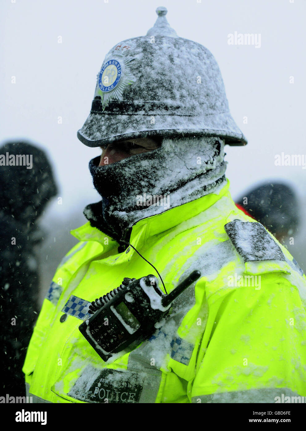 Ein Polizist wacht über die Demonstration von Arbeitern vor der Lindsey Ölfabrik in Killingholme in North Lincolnshire, die heute trotz der arktischen Schneestürme fortgesetzt wird. Stockfoto