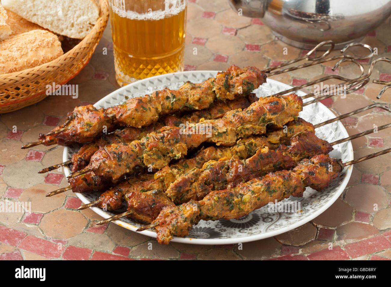 Marokkanischer Lamm Kebab auf einem Tisch mit Tee und brad Stockfoto
