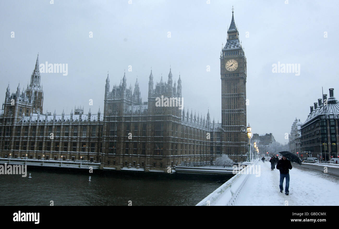Ein Fußgänger überquert die Westminster Bridge vor den Houses of Parliament, nachdem es im Zentrum Londons über Nacht stark geschneit hat. Stockfoto