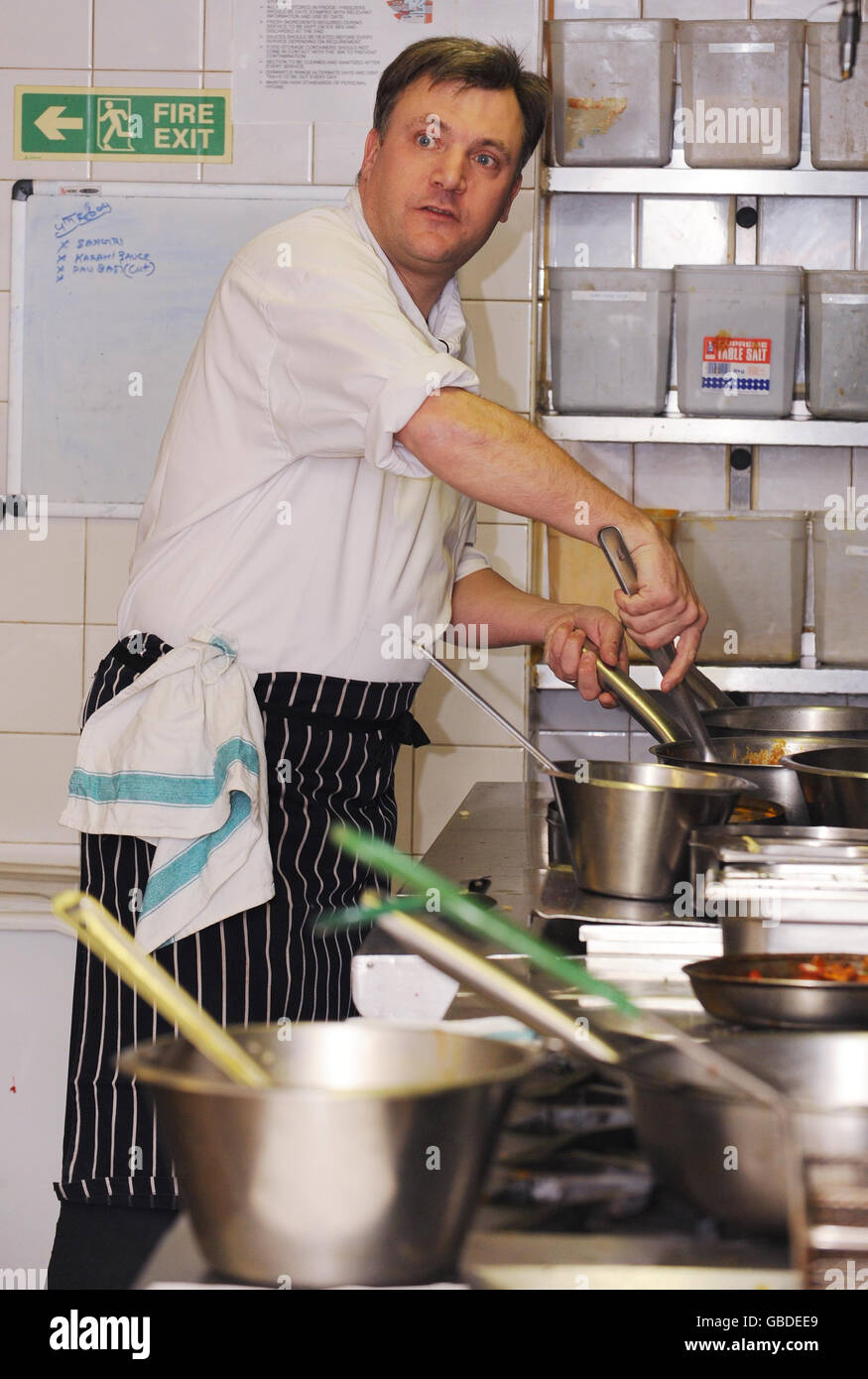 Der Schulsekretär Ed Balls in der Küche des Cinnamon Club Restaurants in Westminster, im Zentrum von London, bereitet ein Curry aus einem Rezeptbuch zu, das im Rahmen einer Regierungsangelegenheit, die Kinder zum Kochen anregt, an die Schüler des Landes verteilt werden soll. Stockfoto