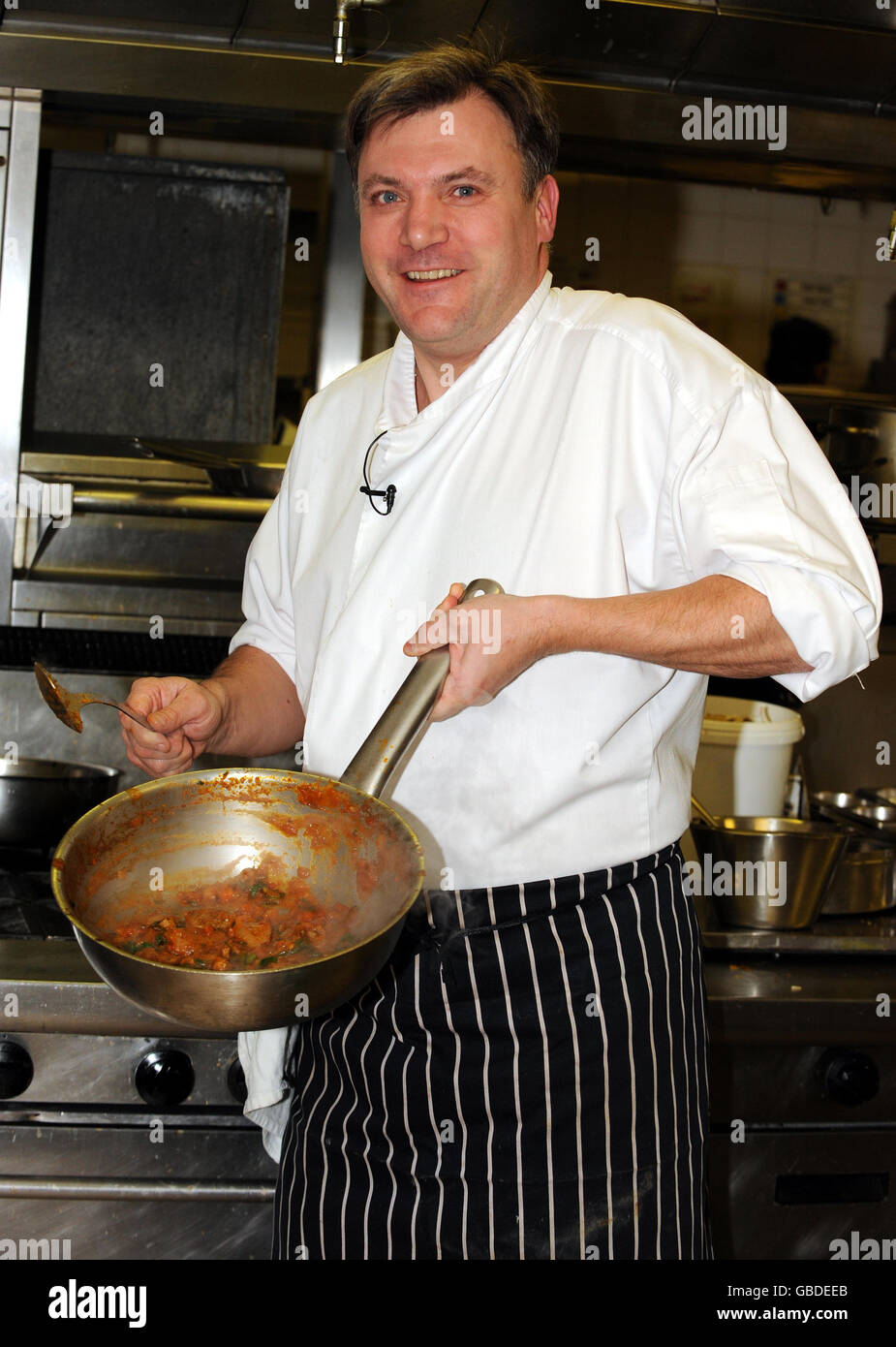 Der Schulsekretär Ed Balls in der Küche des Cinnamon Club Restaurants in Westminster, im Zentrum von London, bereitet ein Curry aus einem Rezeptbuch zu, das im Rahmen einer Regierungsangelegenheit, die Kinder zum Kochen anregt, an die Schüler des Landes verteilt werden soll. Stockfoto