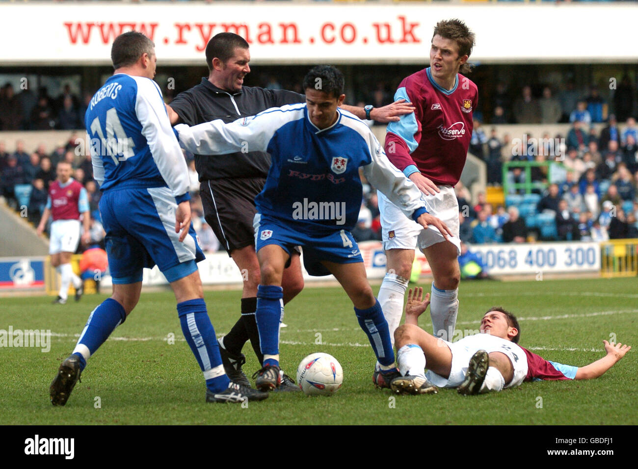 Schiedsrichter Jeff Winterand Millwall's Tim Cahill (c) halten auseinander West Michael Carrick von Ham United (r) und Andy Roberts von Millwall (l) Nachdem Roberts West Ham United's Jon Harley zu geschoben hatte Der Boden Stockfoto