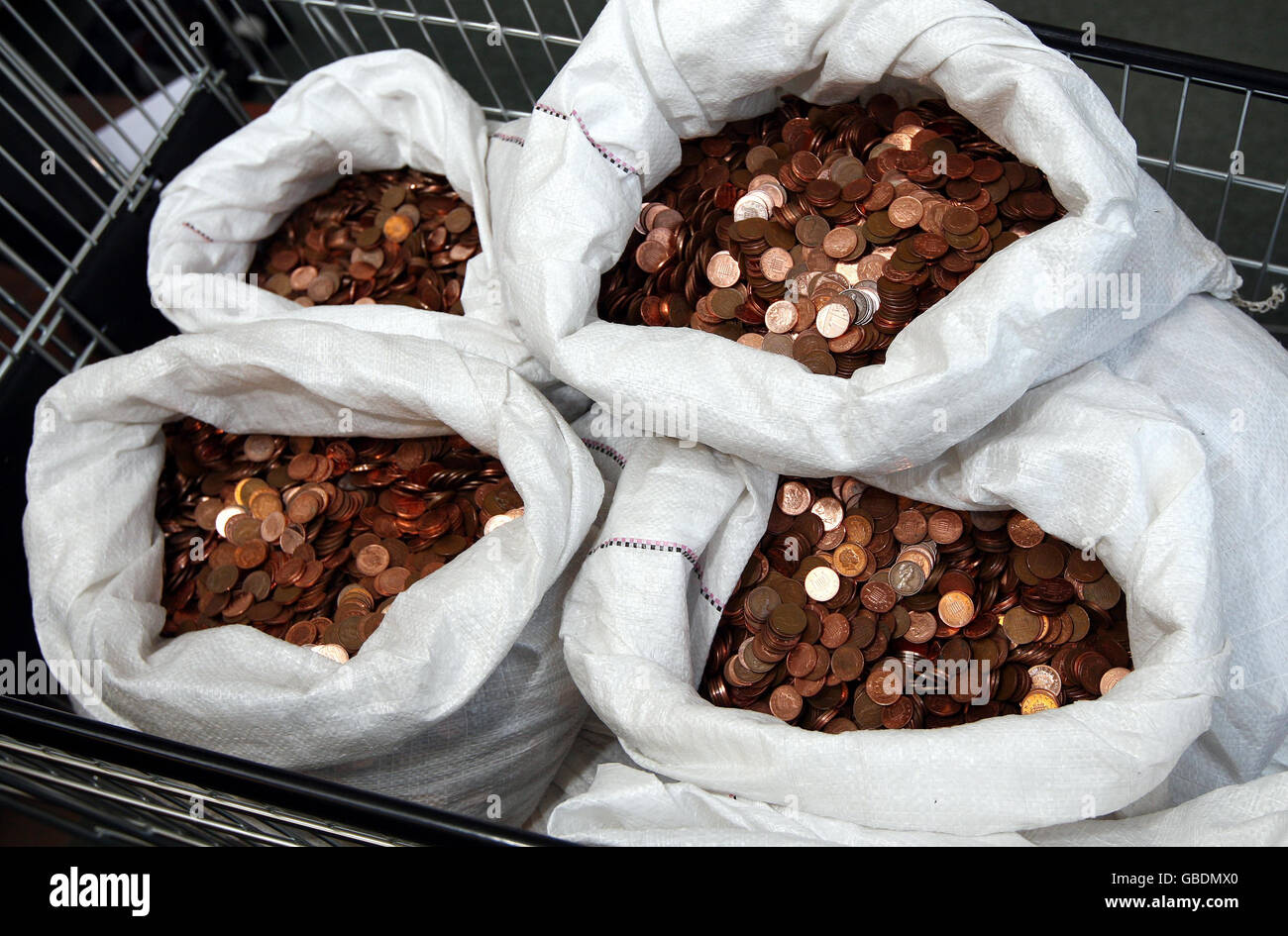 Gary Southall verließ ratsmitarbeiter in Birmingham fassungslos heute, als er versuchte, eine 1,300 Schulden mit Taschen von Pennies in einem Supermarkt Einkaufswagen geladen begleichen. Stockfoto