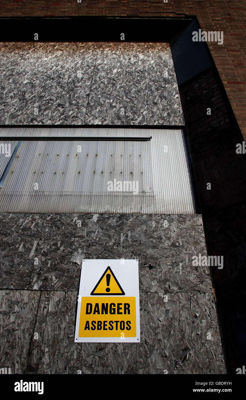 Ein Asbestwarnschild in einem heruntergekommenen Gebiet, das im Schmuckviertel in Hockley, Birmingham, in Entwicklung ist Stockfoto