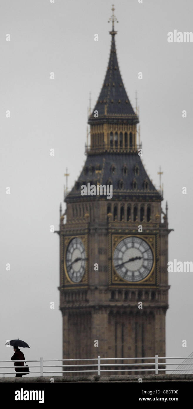Ein Fußgänger überquert die Waterloo Bridge, London, vor dem St. Stephen's Tower, bekannt als „Big Ben“, wenn es stark regnet. Stockfoto