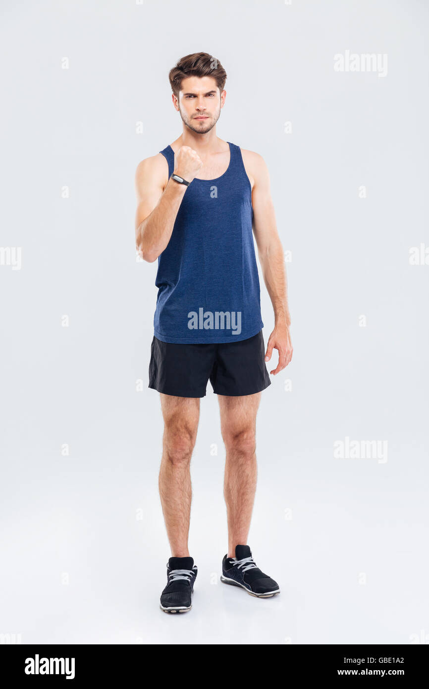 Angry attraktiven Sport-Mann zeigt Faust auf grauem Hintergrund Stockfoto