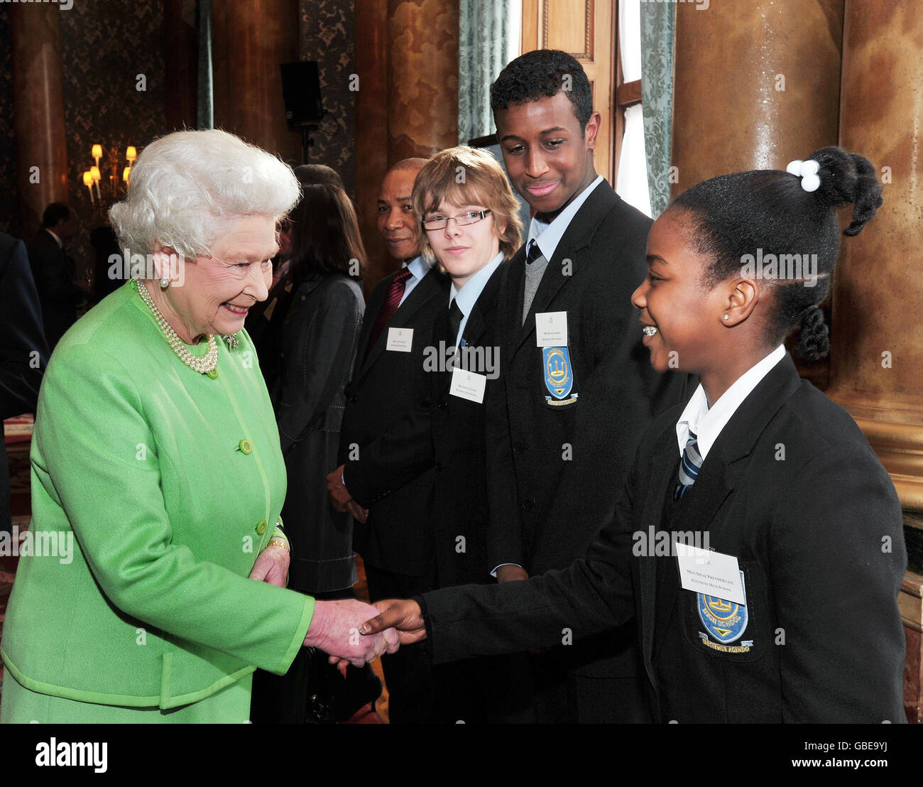 Die britische Königin Elizabeth II. Schüttelt die Hände mit Sinae Prendergast von der Kingbury High School, beobachtet von Schulfreunden Hashi Ahmed (zweite rechts) und Fergus Leahy (dritte rechts), nachdem sie heute Nachmittag die Monarchy-Website im Buckingham Palace im Zentrum von London neu gestartet hat. Stockfoto