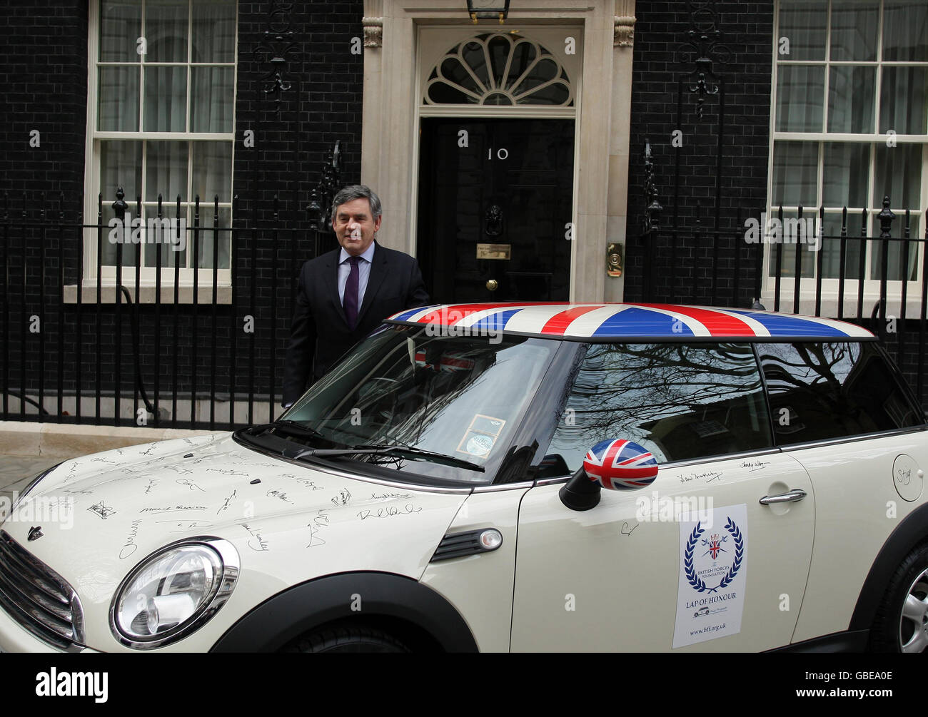 Der britische Premierminister Gordon Brown posiert für Fotos, nachdem er einen Mini zur Unterstützung der British Forces Foundation vor der Downing Street 10 in London signiert hat. Stockfoto