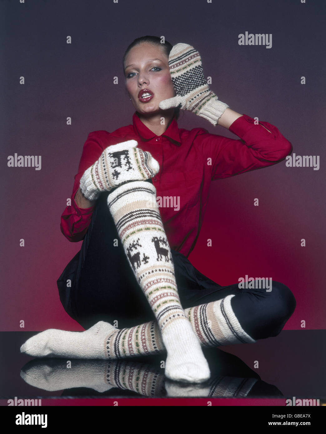 Mode, 80er Jahre, junge Frau mit gemustertem Wollstrumpf und Wollhandschuhen, sitzend, Additional-Rights-Clearences-not available Stockfoto