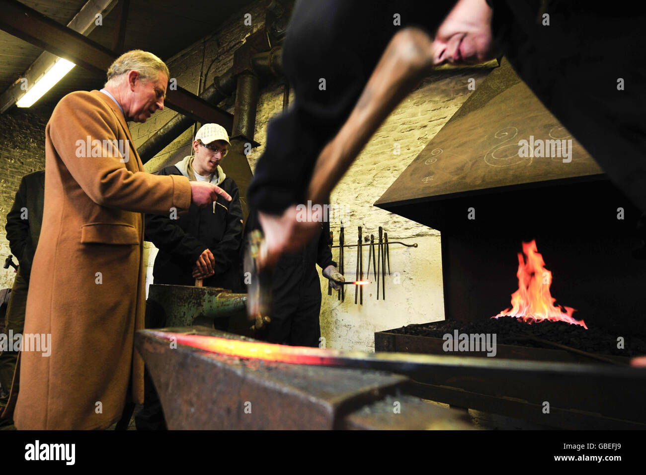 Der Prinz von Wales (links) chattet mit Studenten, die Schmiedekunst studieren, während eines Besuchs im Rural Skills Center in Cirencester, Gloucestershire. Stockfoto