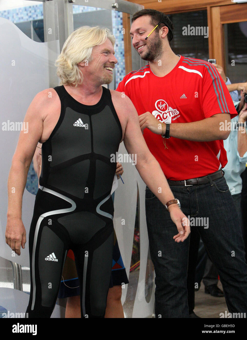 Ian Thorpe (rechts) bringt den letzten Schliff an Sir Richard Branson Schwimmanzug, als sie offiziell das Virgin Active Gym in Sydney, Australien, eröffnen, indem sie an einem Schwimmrennen teilnahm, bei dem seine Virgin Atlantic Mannschaft gegen eine australische olympische Schwimmmannschaft antritt. Stockfoto