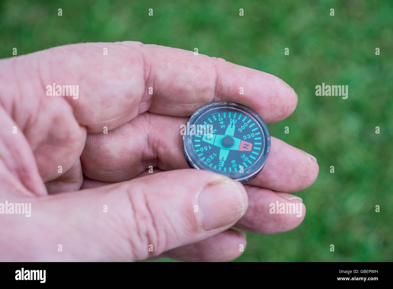 Konzept von Richtung Navigation, und zu wissen, wohin Sie gehen oder ihren Weg finden, von einer Hand dargestellt - magnetische Taste Kompass statt. Stockfoto