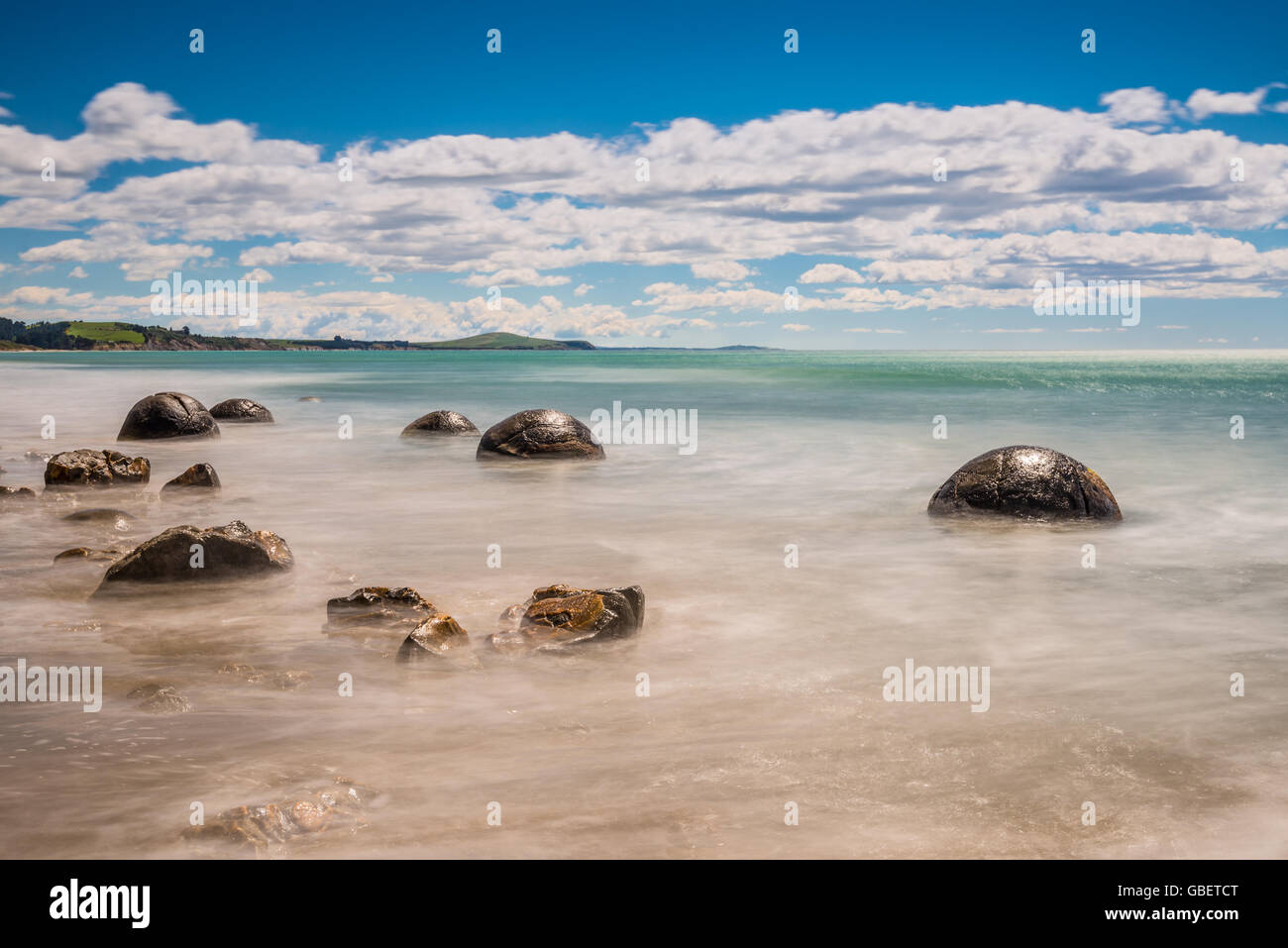 Langzeitbelichtung Bild von Moeraki Boulders liegend auf einer Strecke von Koekohe Strand auf der Otago-Küste Neuseelands in der Welle-Schnitt Stockfoto