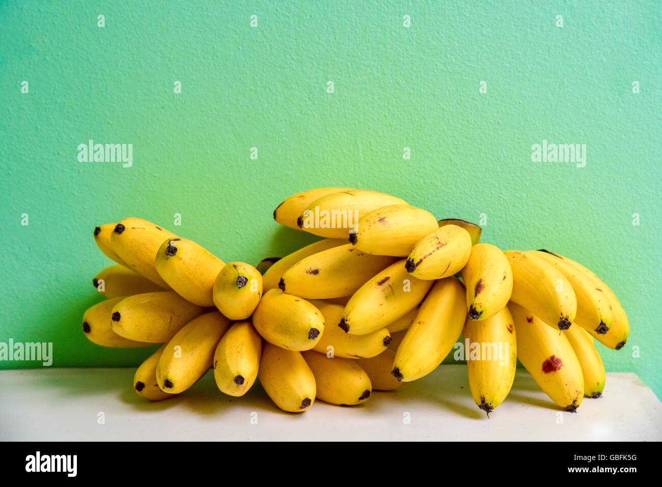 Bündel von Lady Finger Bananen liegen auf einem Regal Stockfoto