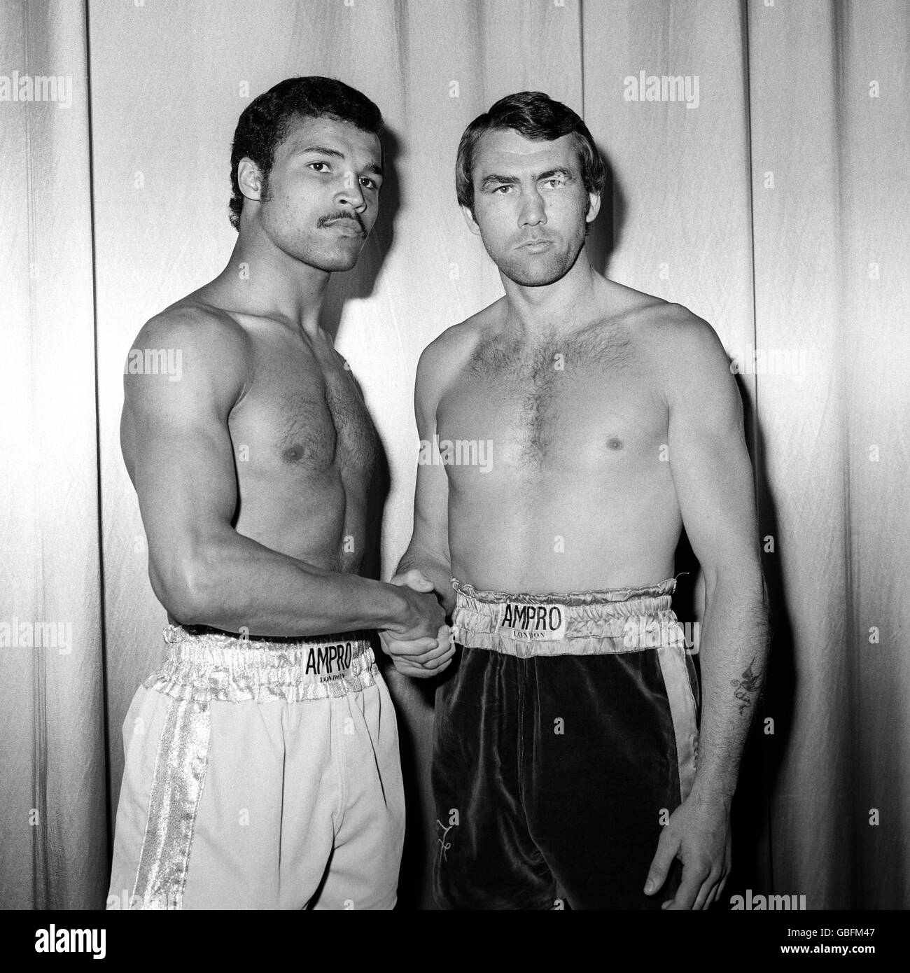 Der dreifache Schwergewichtsmeister John Conteh, links, schüttelt sich die Hände mit dem ehemaligen Champion und Herausforderer Chris Finnegan auf dem Odeon, Leicester Square, wo sie sich trafen, um sich für den Kampf im Wembley Empire Pool einzuwägen. Stockfoto