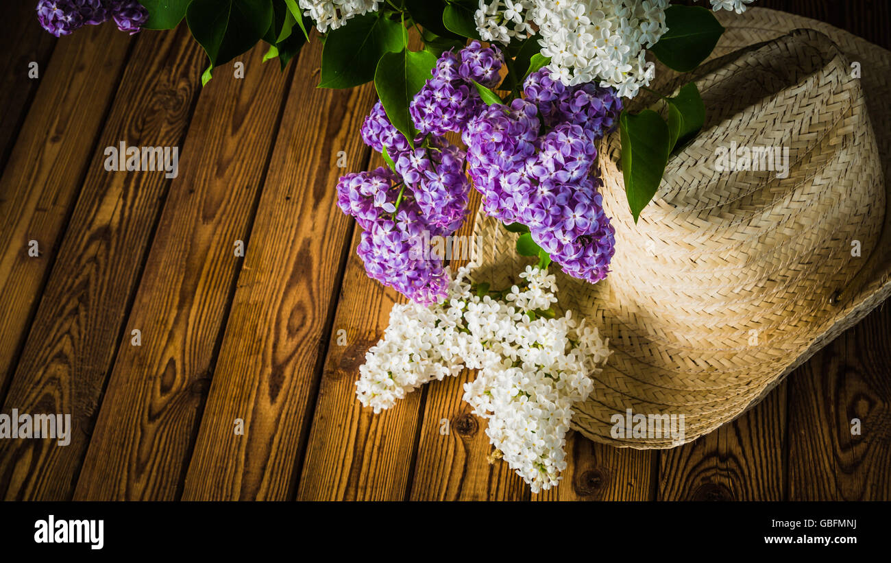 Stillleben mit einem Bouquet von Flieder und einen Strohhut, close-up Stockfoto