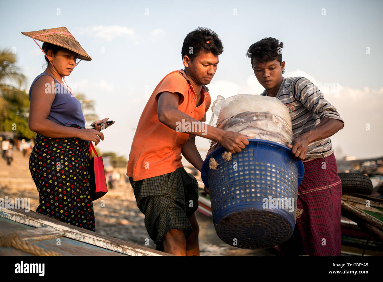 YANGON, MYANMAR - 3. Januar 2016: Pier Arbeiter laden Korb voller gefrorenen Fisch das Boot am Pier Steg Yangon, Myanmar. Stockfoto