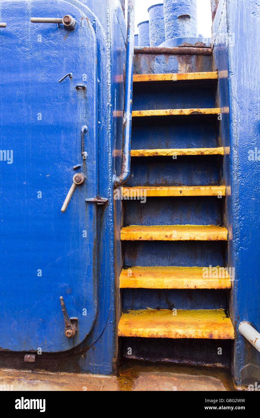 Gelbe Schritte auf ein blaues Boot Stockfoto