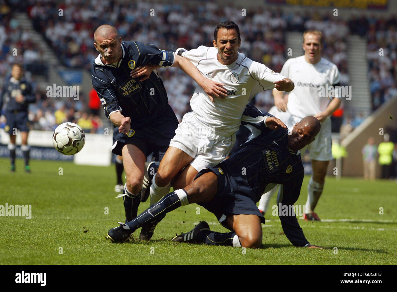 Youri Djorkaeff von Bolton Wanderers kämpft mit Leeds um den Ball United's Dominic Matteo (l) und Michael Duberry (r) Stockfoto Youri Djorkaeff von Bolton Wanderers kämpft mit Leeds um den Ball United's Dominic Matteo (l) und Michael Duberry (r) Stockfoto