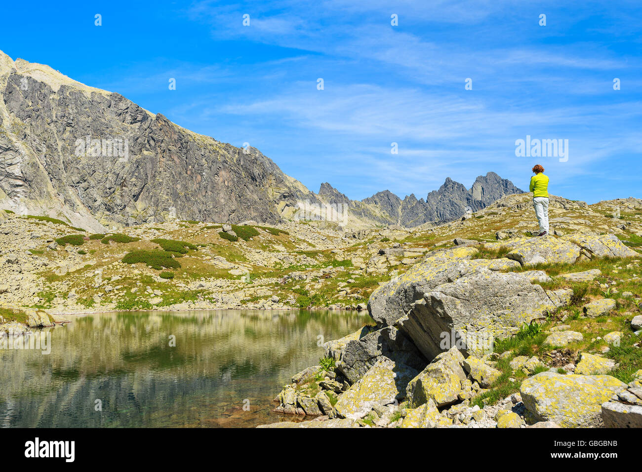 Junge Frau Touristen steht auf einem Felsen am Ufer des Bergsee im Sommerlandschaft des Starolesna-Tals, hohe Tatra montieren Stockfoto