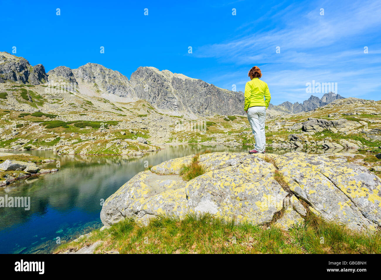 Junge Frau Touristen steht auf einem Felsen am Ufer des Bergsee im Sommerlandschaft des Starolesna-Tals, hohe Tatra montieren Stockfoto