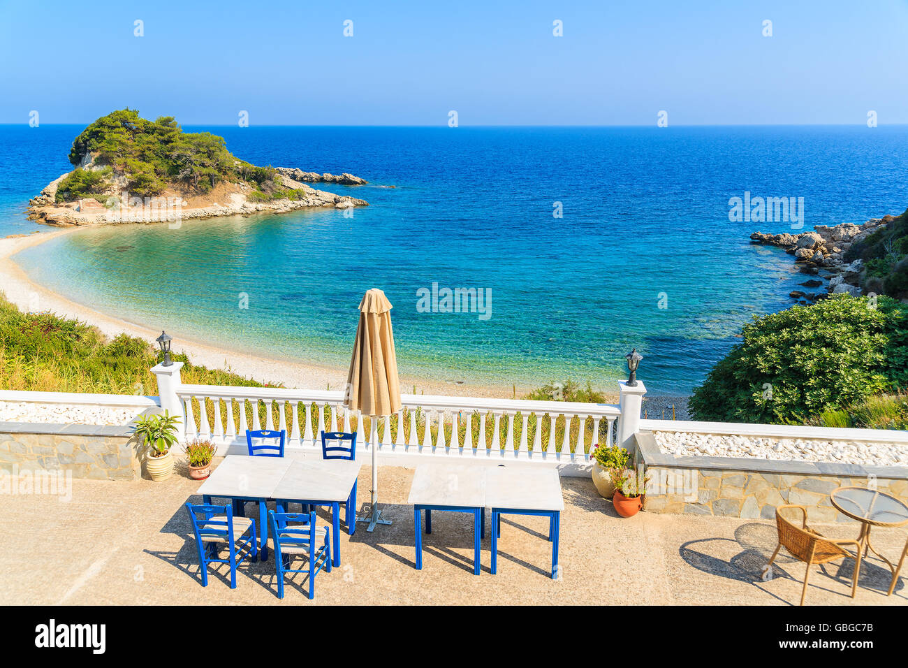 Tische mit Stühlen auf der Terrasse mit Blick auf Bucht von Kokkari, Insel Samos, Griechenland Stockfoto