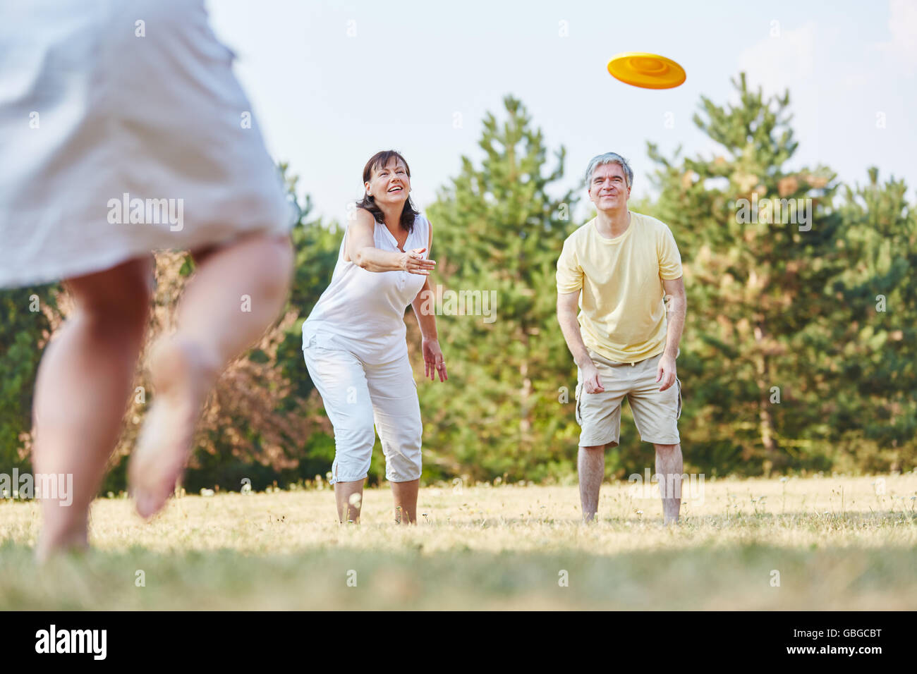 Gruppe von Seniorinnen und Senioren spielen Frisbee in den park Stockfoto