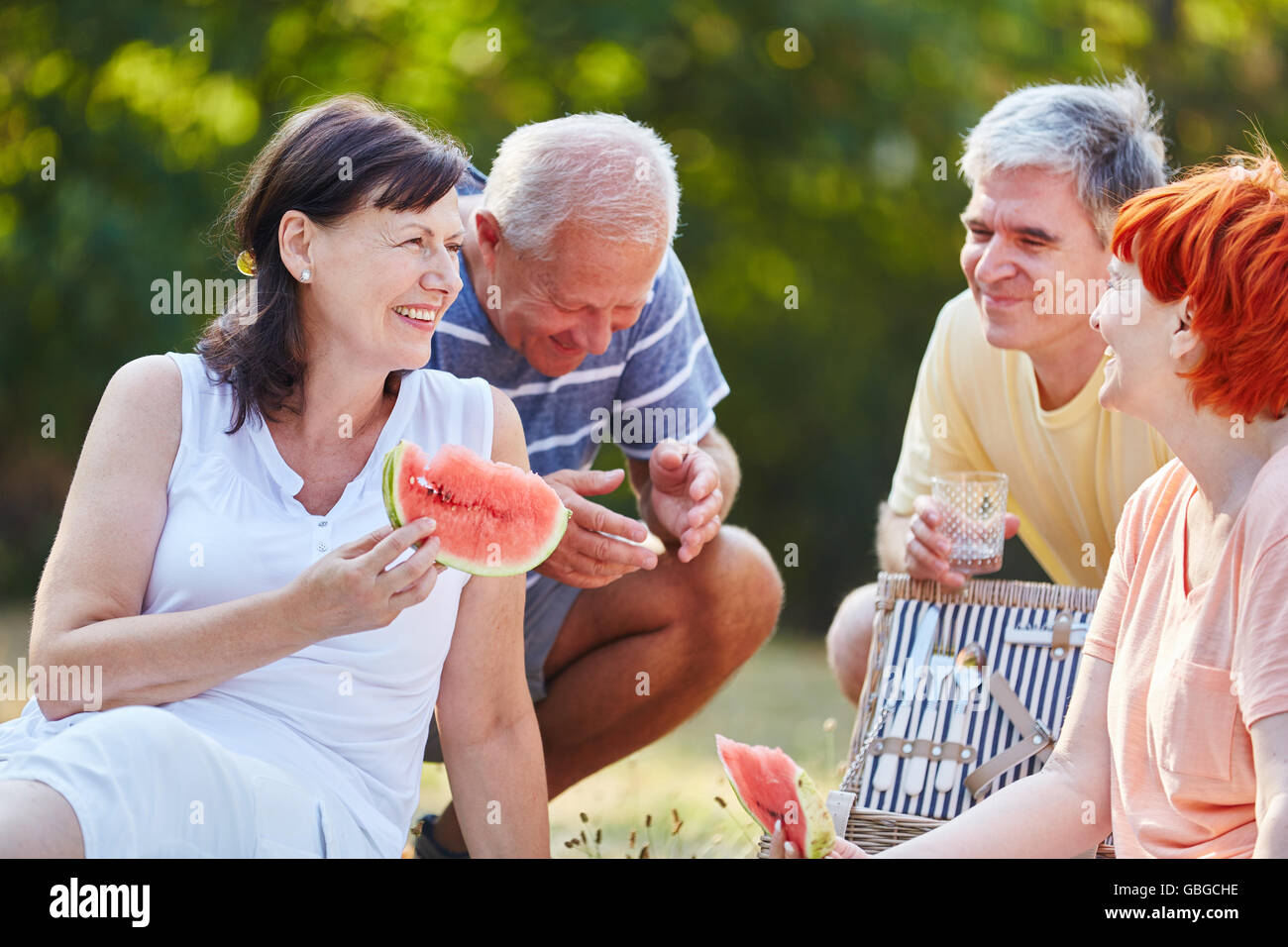 Senioren machen ein Picknick im Park im Sommer Obst essen Stockfoto