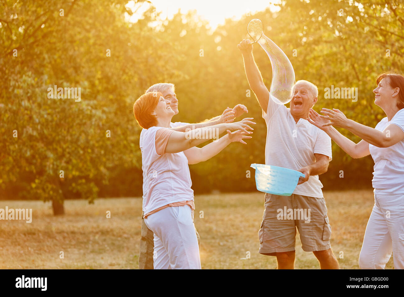 Senioren Freunde Spaß und macht Seifenblasen im park Stockfoto