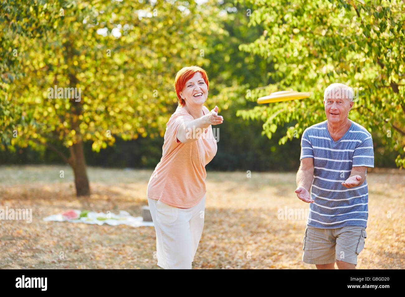 Älteres paar Frisbee zu spielen und Spaß im Sommer im park Stockfoto