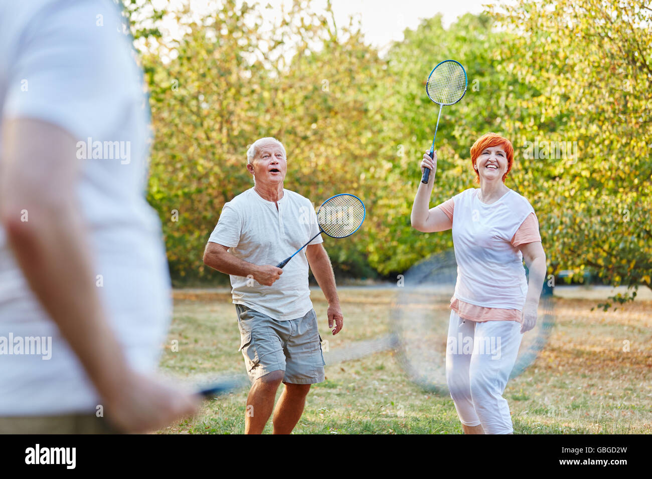 Aktive Senioren spielen Badminton im Park im Sommer Stockfoto