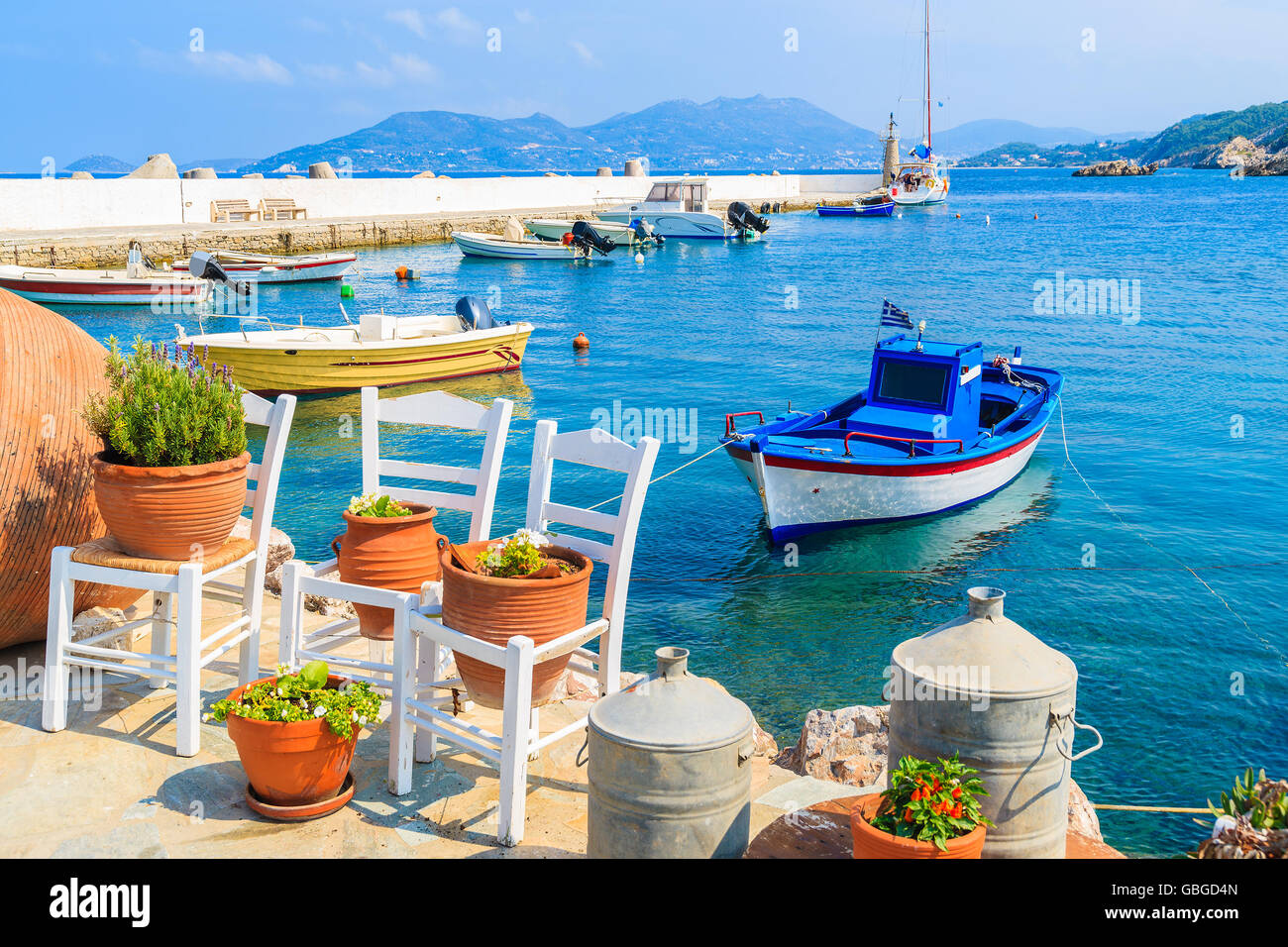 Blume Töpfe auf und Anzeigen der Angelboote/Fischerboote ankern in Kokkari Bucht, Insel Samos, Griechenland Stockfoto