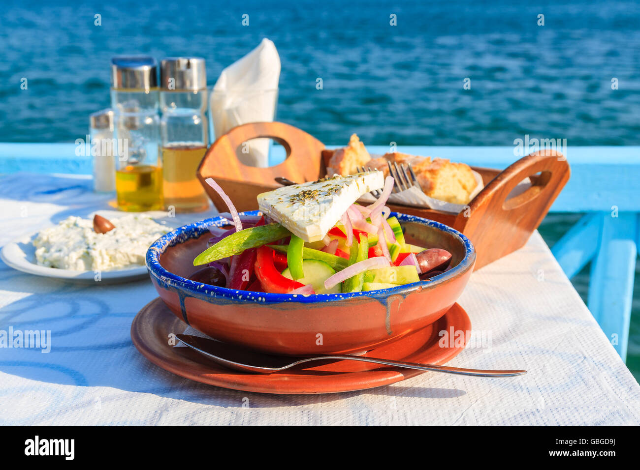 Griechischer Salat am Tisch in griechischen Taverne mit blauen Meerwasser im Hintergrund die Insel Samos, Griechenland Stockfoto