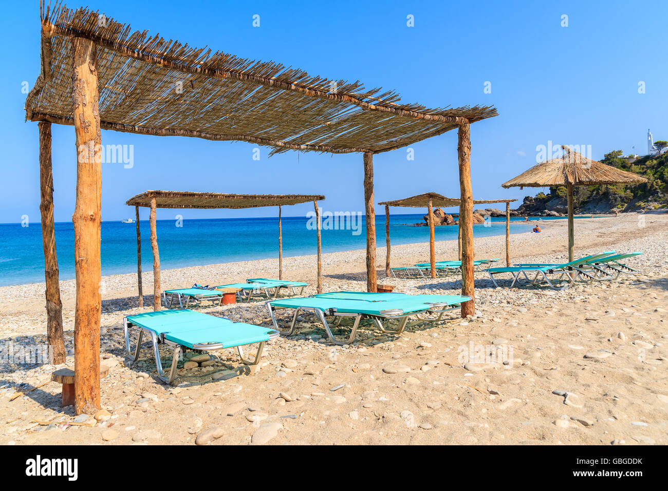 Sonnenliegen am Strand von Potami, Insel Samos, Griechenland Stockfoto