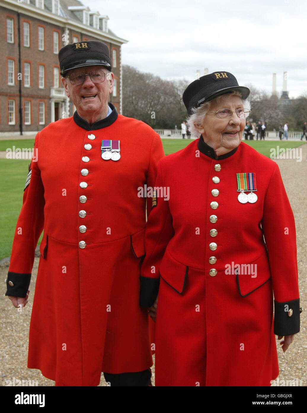 Der Chelsea-Rentner Geoff Crowther begrüßt Dorothy Hughes, eine der ersten Chelsea-Rentnerinnen, im Royal Hospital Chelsea in London. Stockfoto