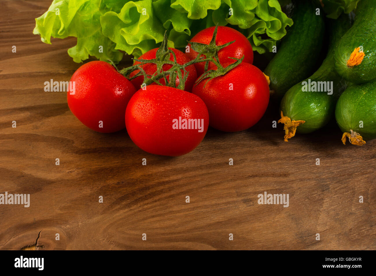 Cherry-Tomaten und Gurken auf Holztisch. Tomaten.  Gurke.  Reife Gemüse. Frisches Gemüse. Cherry-Tomate. Gesunde eati Stockfoto
