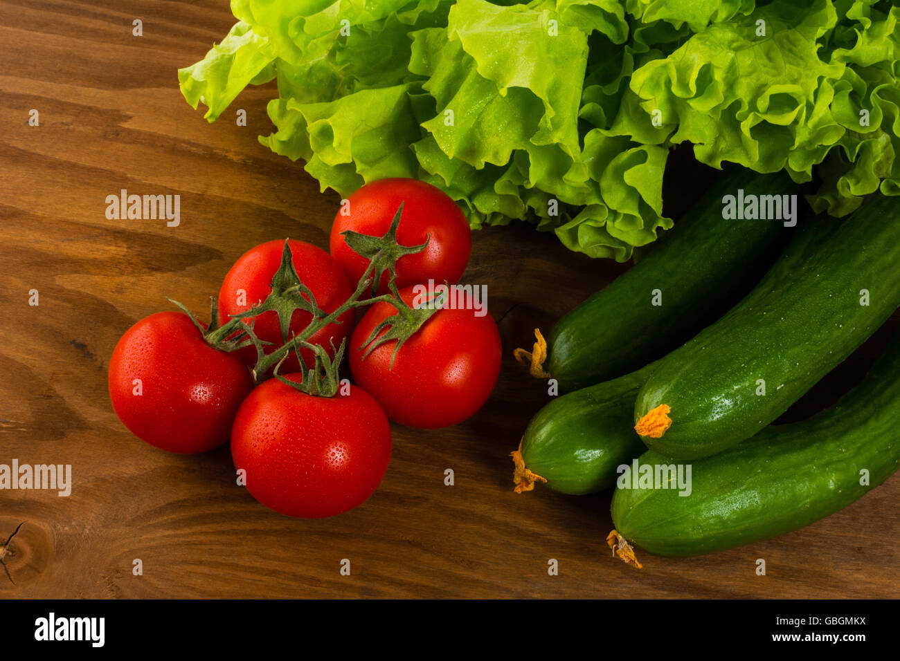 Gurken und Tomaten auf dunklen Holztisch. Tomaten.  Gurke.  Reife Gemüse. Frisches Gemüse. Cherry-Tomate. Gesund Stockfoto