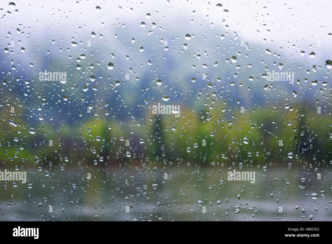 Blick auf den Fluss durch Fenster in regnerischen Tag. Regnerischen Tag. Regentropfen. Regentropfen Hintergrund. Stockfoto