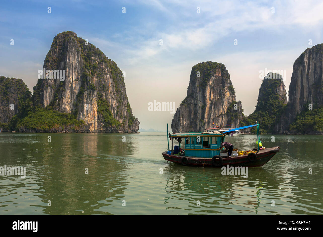 Ein Boot zwischen Dao Dau Go und Hon Cap Ngan, zwei von den Hunderten von Inseln in Ha Long Bay, Provinz Quang Ninh, Vietnam Stockfoto