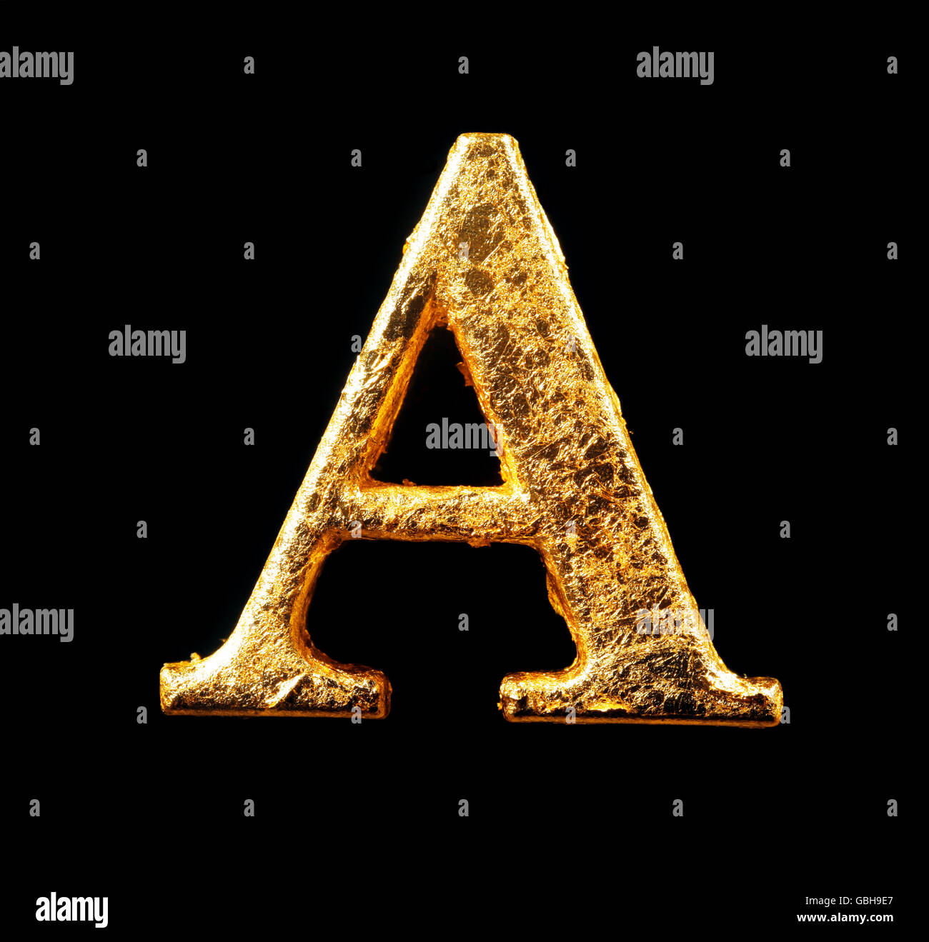 Alphabet und Zahlen in Blattgold isoliert auf schwarz Stockfoto