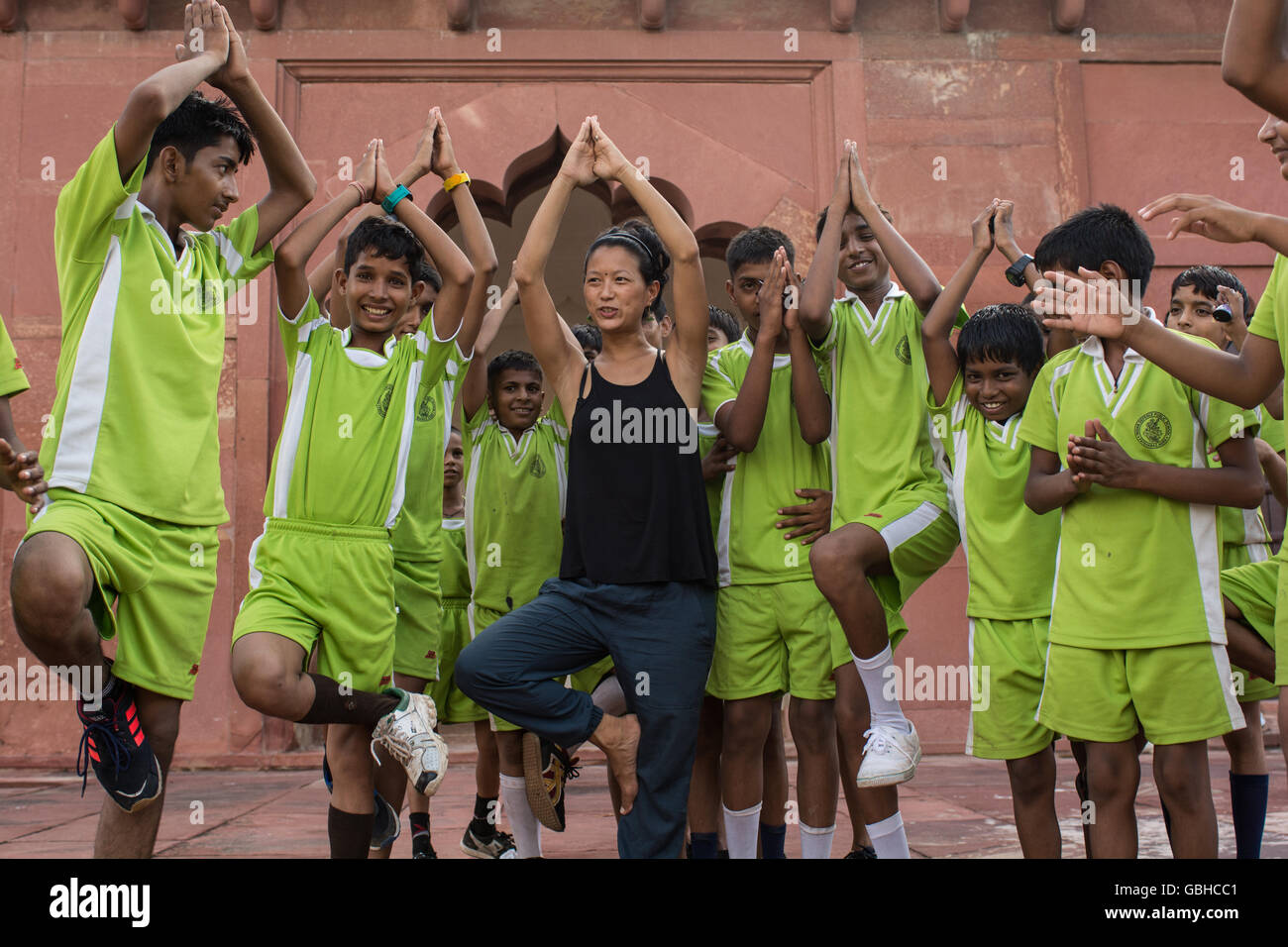 Frau, Yoga-Unterricht mit Kindern Studenten in Neu-Delhi, Indien. Stockfoto