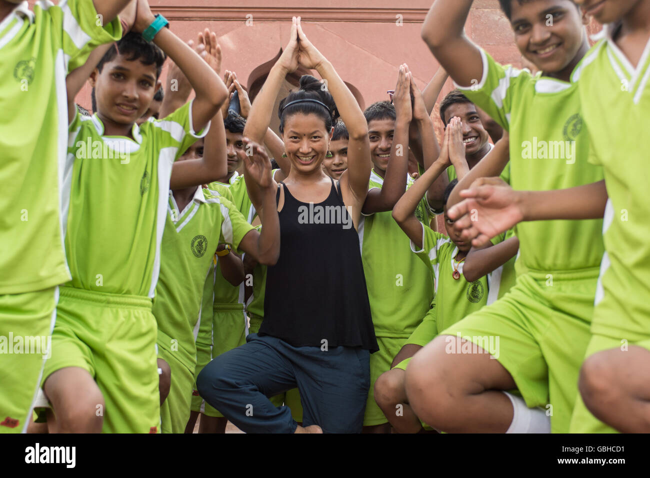 Frau, Yoga-Unterricht mit Kindern Studenten in Neu-Delhi, Indien. Stockfoto