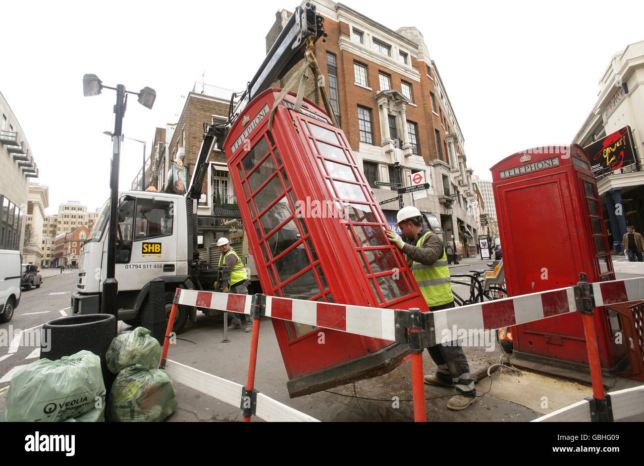 Arbeiter entfernen eine rote öffentliche Telefondose aus Covent Garden im Zentrum von London. Stockfoto
