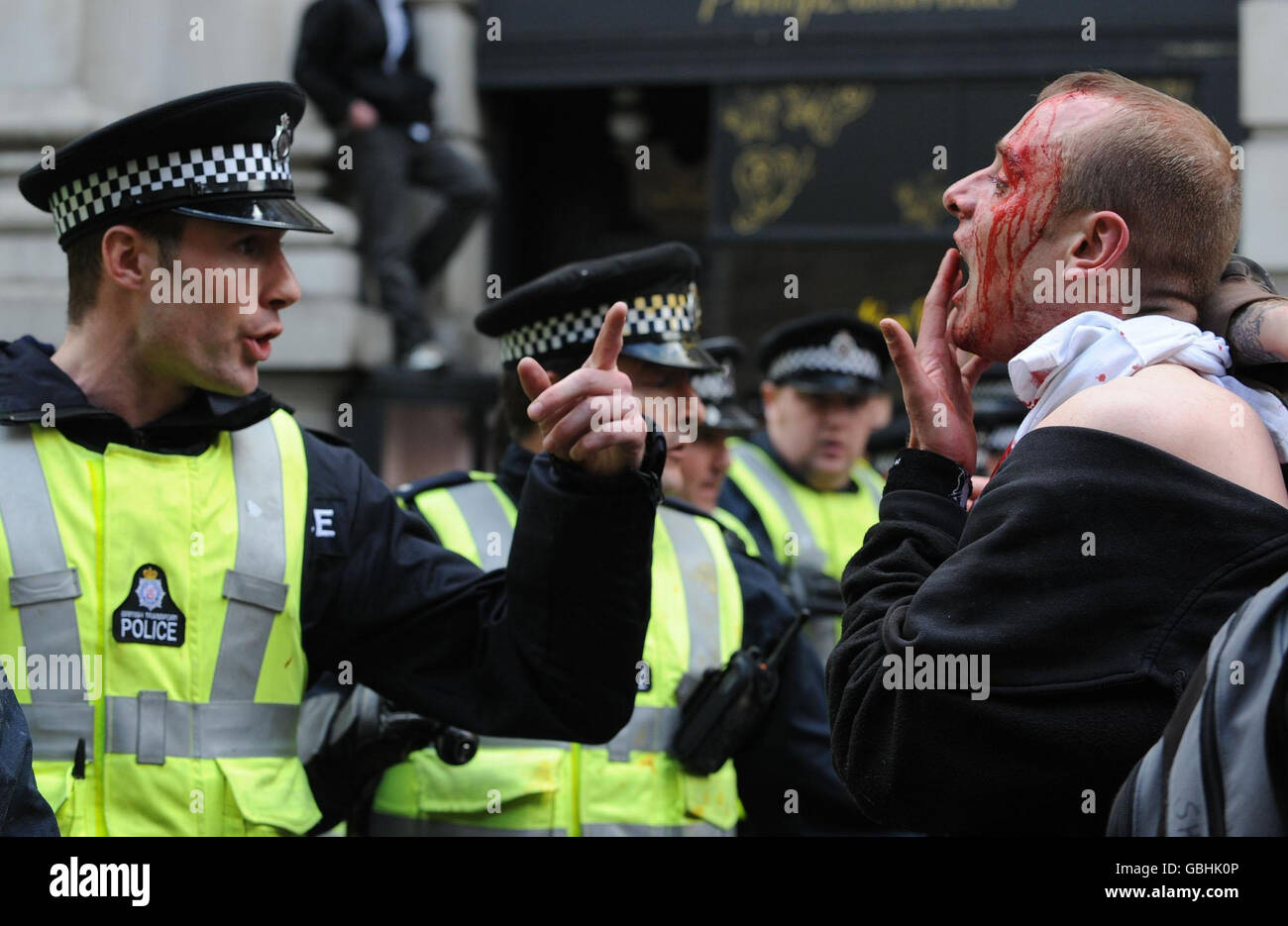 Ein verletzter Mann konfrontiert die Polizei, während sie versuchen, die Massen in der Nähe der Bank of England zu unterwerfen, während der G20-Proteste im Zentrum von London. Stockfoto