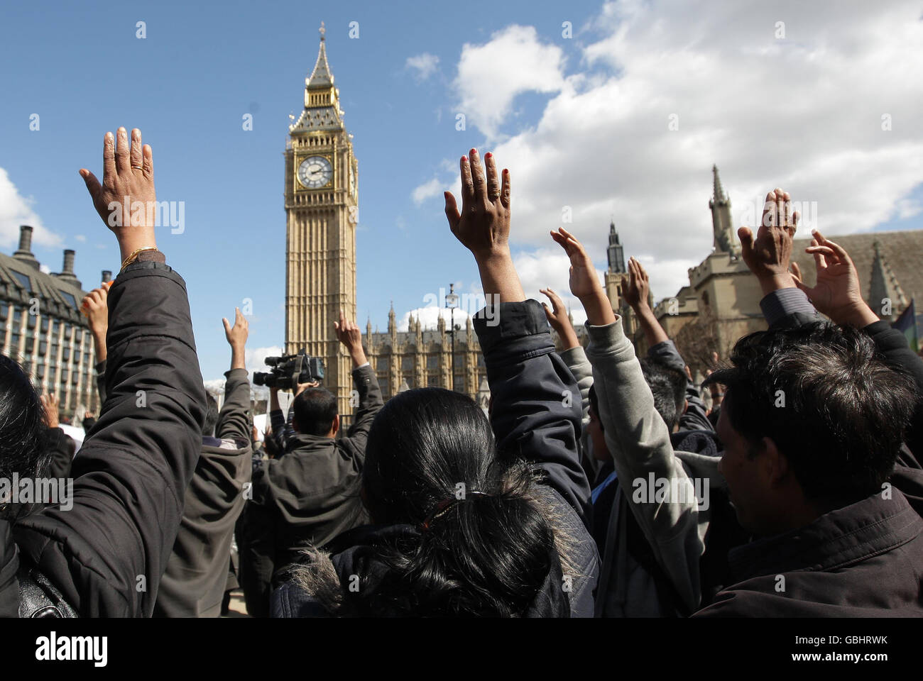 Während eines Schweigeminuten heben die Demonstranten ihre Hände auf, während sie an einem Protest teilnehmen, um einen sofortigen Waffenstillstand in Sri Lanka, am Parliament Square, Westminster, London, zu fordern. Stockfoto