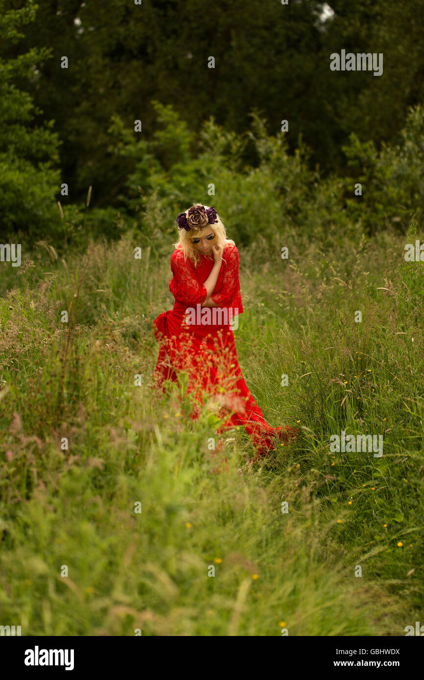 Blonde romantische Fee Elfe Modell in Wiese mit mit gold lila rose Krone Kopfschmuck, kontemplative, dramatische Stockfoto