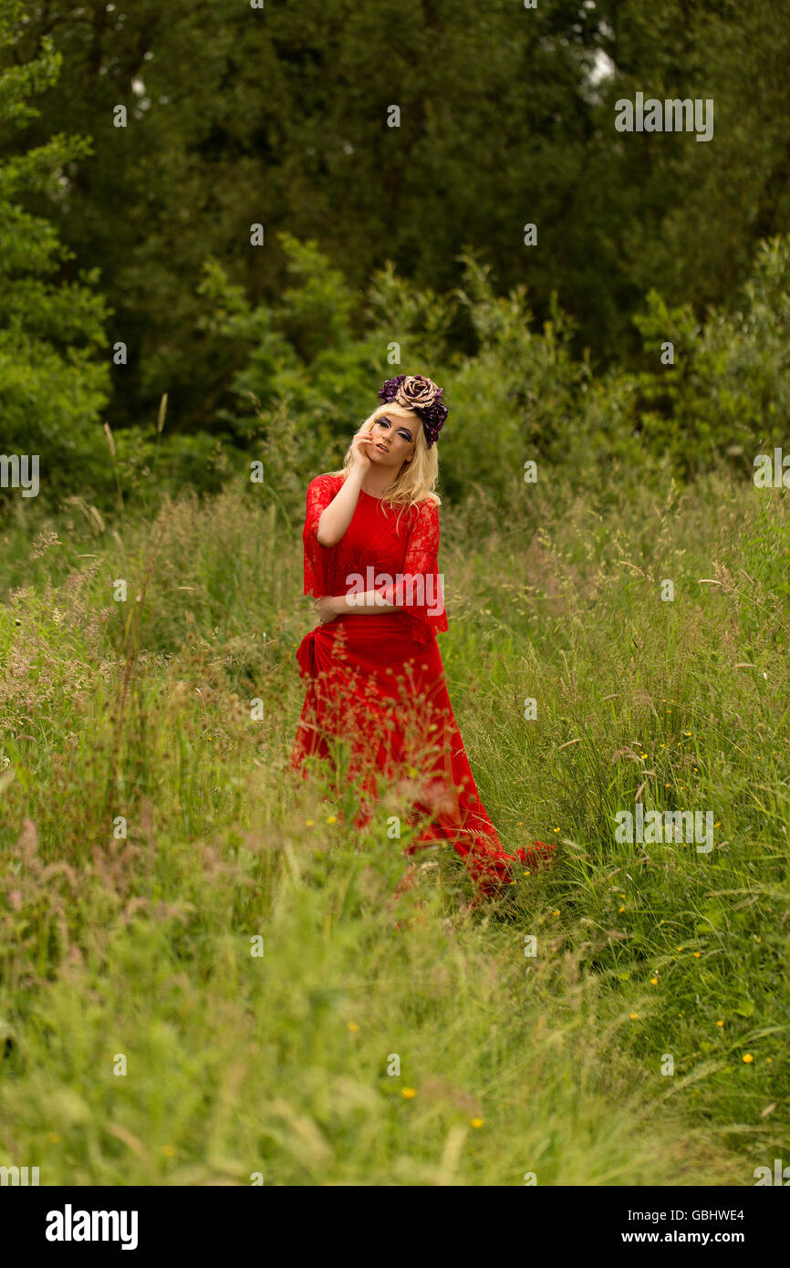 Blonde romantische Fee Elfe Modell in Wiese mit mit gold lila rose Krone Kopfschmuck, kontemplative, dramatische Stockfoto