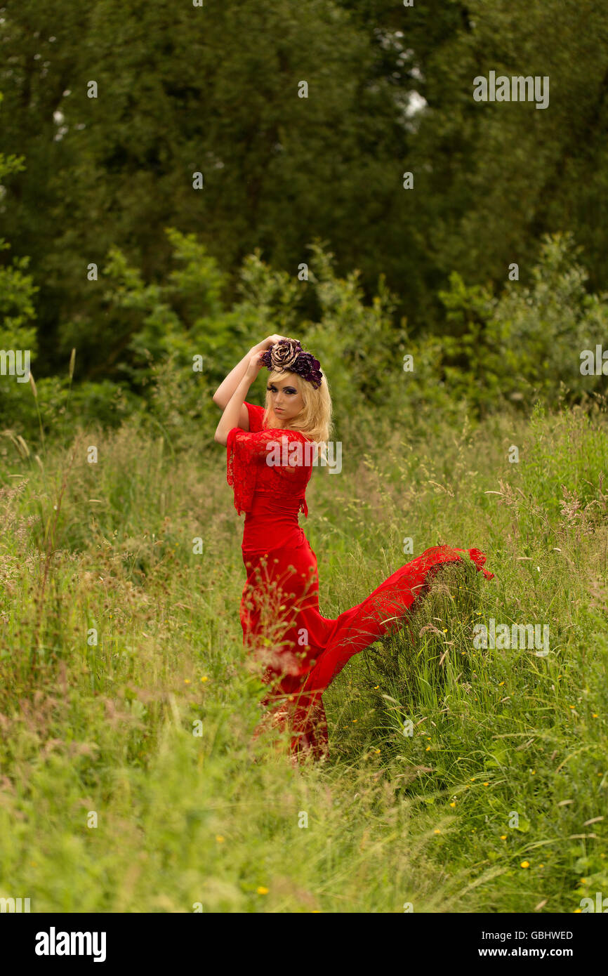 Blonde romantische Fee Elfe Modell in Wiese mit mit gold lila rose Krone Kopfschmuck, kontemplative, dramatische Stockfoto